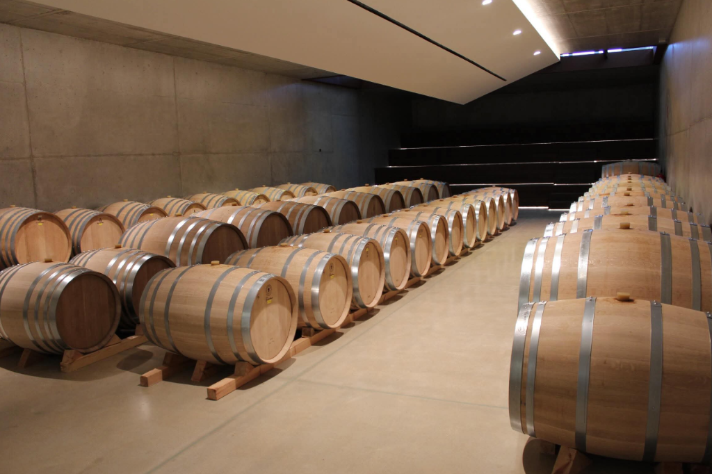 Sala de crianza de Bodega Aalto con barricas de roble alineadas bajo techo abovedado